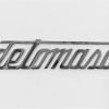 DT10 Scritta DE TOMASO, cromata, mm.150X32, con 2 perni a tergo