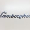 LB36 Scritta LAMBORGHINI corsivo, cromata lucida, lunghezza mm.390, con 4 perni a tergo